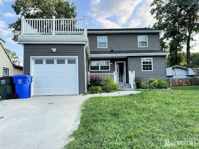traditional home with a front yard, a garage, fence, a balcony, and concrete driveway