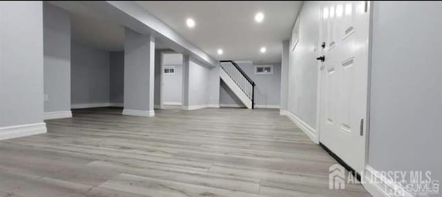 interior space featuring recessed lighting, baseboards, light wood finished floors, and stairway