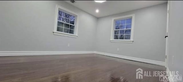 empty room with baseboards and wood finished floors
