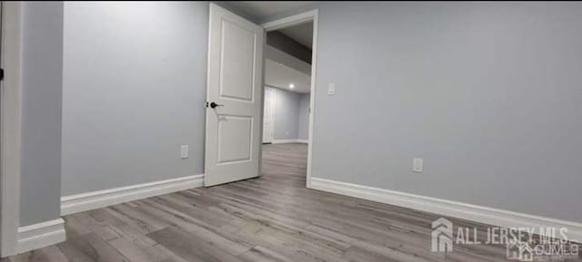 unfurnished room with baseboards and wood finished floors