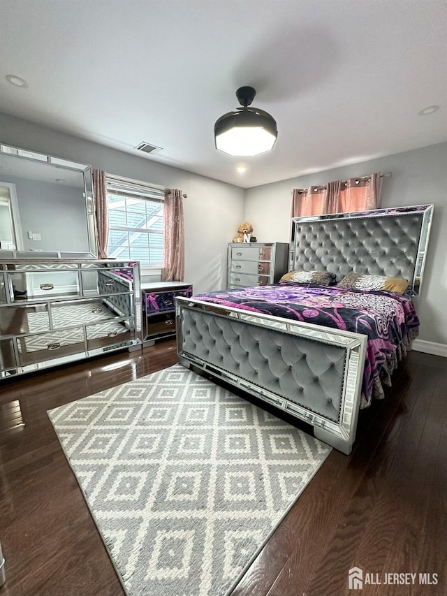 bedroom with visible vents and wood finished floors