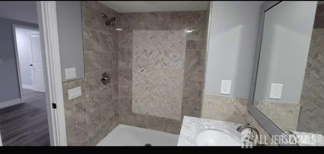 full bathroom with vanity, tile walls, and tiled shower
