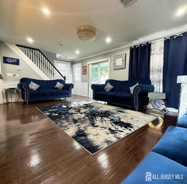 living area featuring stairs, crown molding, visible vents, and wood-type flooring