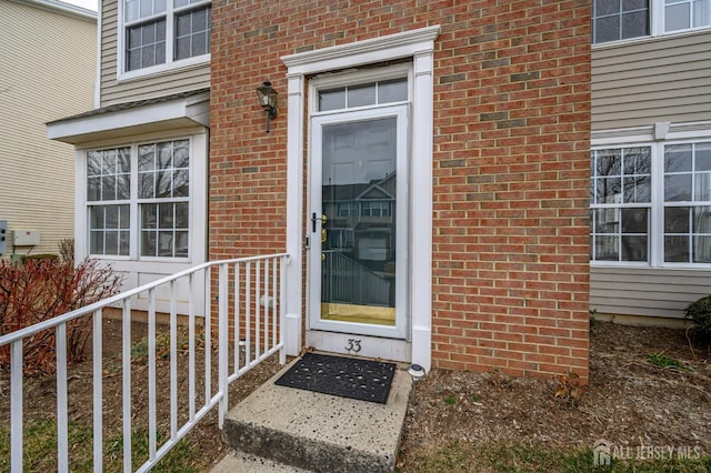 doorway to property with brick siding