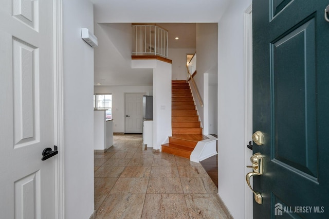 entryway featuring recessed lighting, stairway, baseboards, and stone tile floors