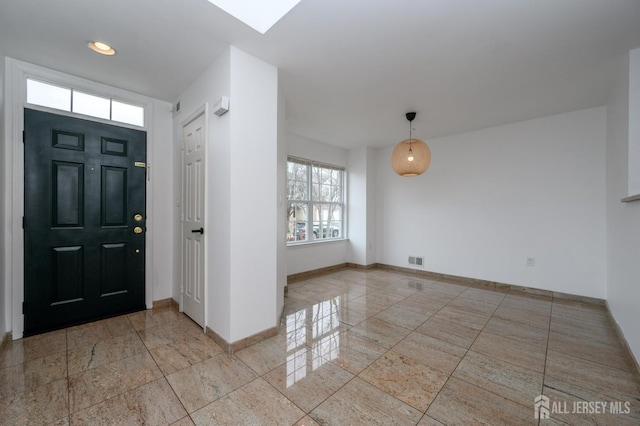 entrance foyer featuring a skylight, baseboards, and visible vents