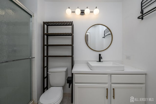 full bathroom featuring toilet, a shower stall, and vanity