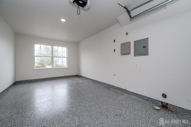 empty room with recessed lighting, electric panel, baseboards, and speckled floor