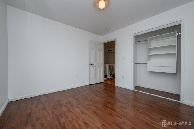 unfurnished bedroom featuring wood finished floors and baseboards