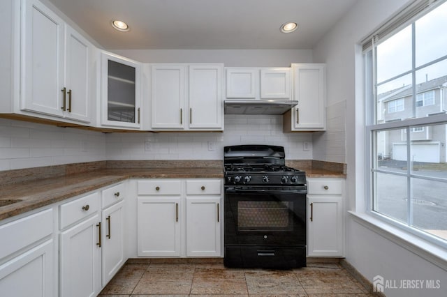 kitchen with black gas range, under cabinet range hood, and white cabinets