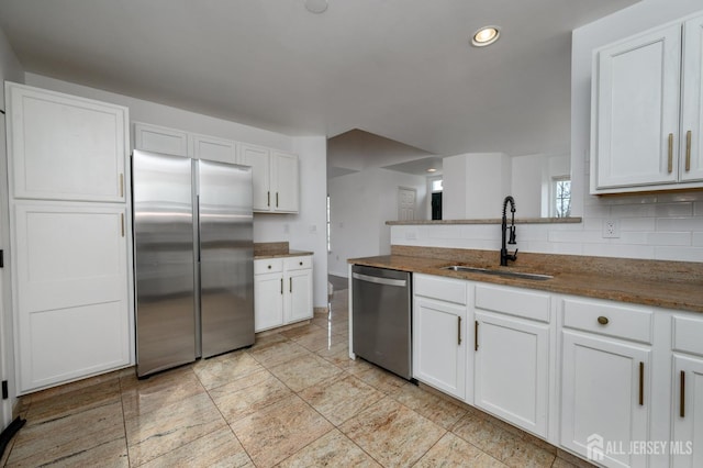 kitchen featuring a sink, recessed lighting, stainless steel appliances, white cabinets, and decorative backsplash