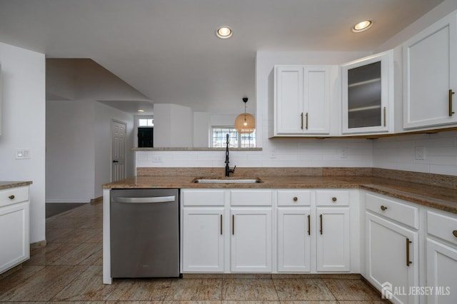 kitchen featuring backsplash, glass insert cabinets, stainless steel dishwasher, white cabinets, and a sink