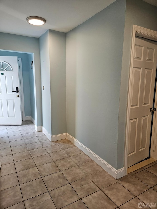 entryway featuring light tile patterned flooring and baseboards