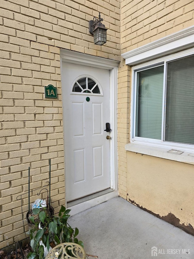 doorway to property with brick siding