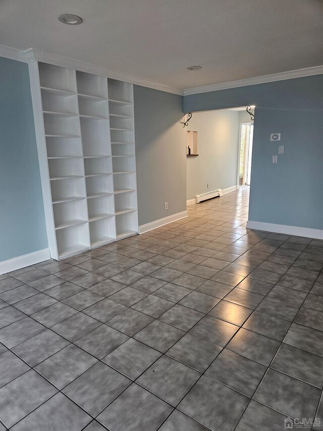 empty room featuring a baseboard heating unit, built in features, and ornamental molding