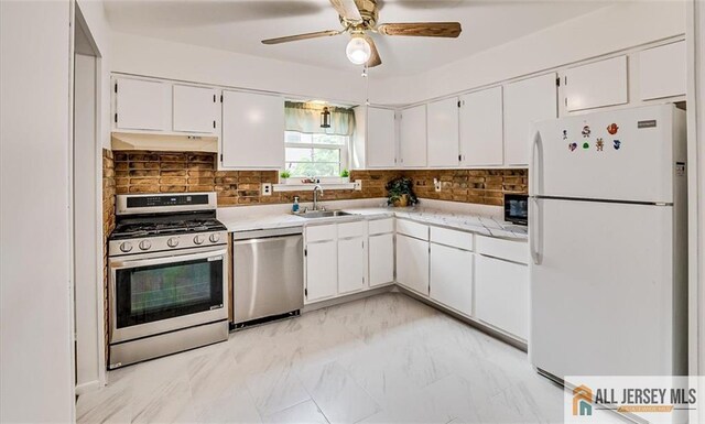 7402 Hana Rd, Edison, NJ 08817 - kitchen with appliances with stainless steel finishes, light countertops, white cabinets, and tasteful backsplash