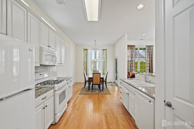 kitchen with white appliances, white cabinetry, tasteful backsplash, and sink