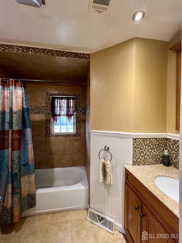 bathroom with visible vents, wainscoting, shower / bath combo with shower curtain, and vanity