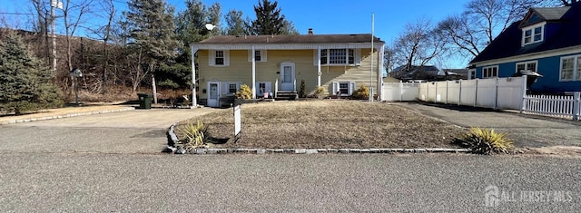 raised ranch featuring fence and driveway