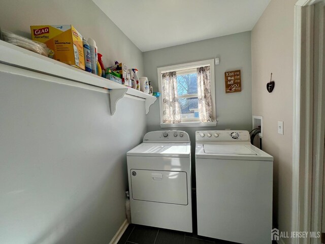 laundry room with laundry area, dark tile patterned flooring, and washing machine and dryer