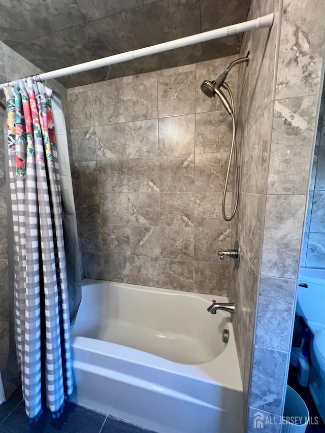 bathroom with shower / bath combo with shower curtain and tile patterned flooring