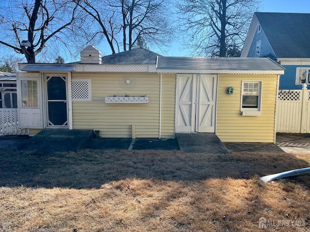 view of outbuilding with fence and entry steps