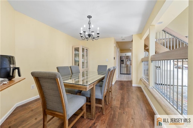 dining area featuring an inviting chandelier and dark hardwood / wood-style flooring