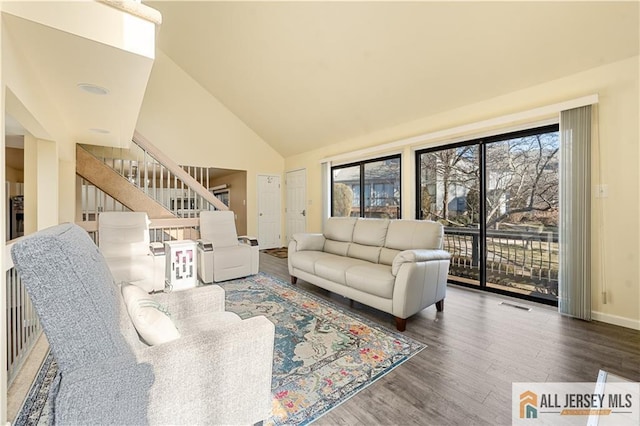 living room featuring high vaulted ceiling and dark hardwood / wood-style floors