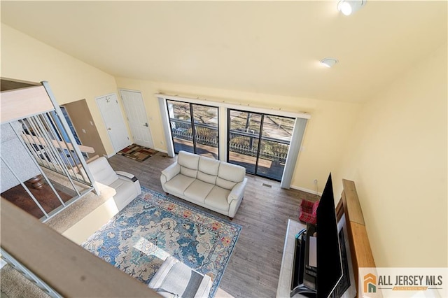 living room with vaulted ceiling and wood-type flooring