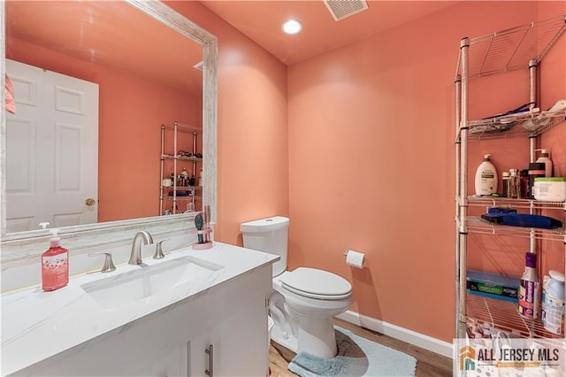 bathroom featuring hardwood / wood-style flooring, vanity, and toilet