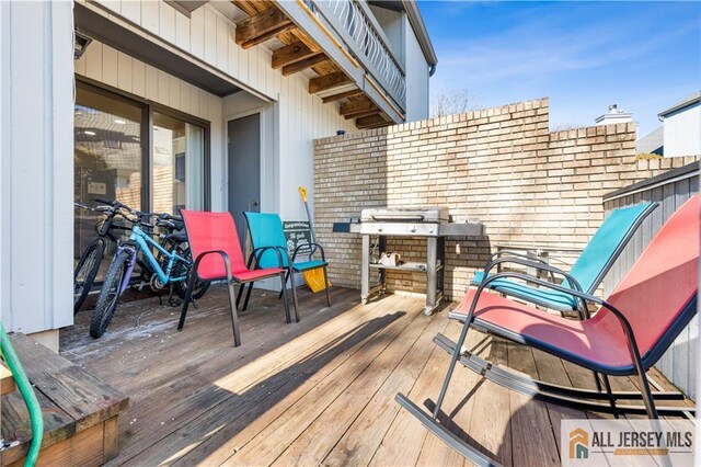 wooden terrace featuring a grill