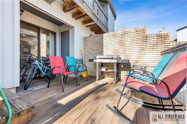 wooden terrace featuring a grill