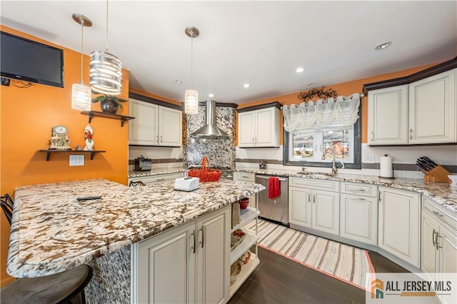 kitchen featuring a breakfast bar, wall chimney range hood, light stone countertops, dishwasher, and a sink