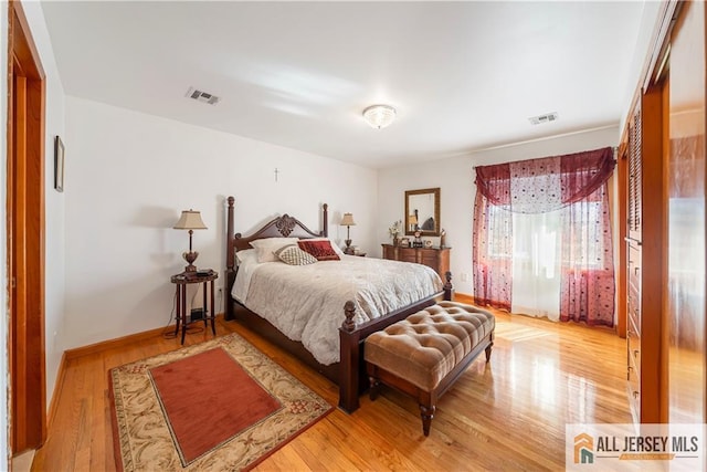 bedroom featuring visible vents, baseboards, and wood finished floors