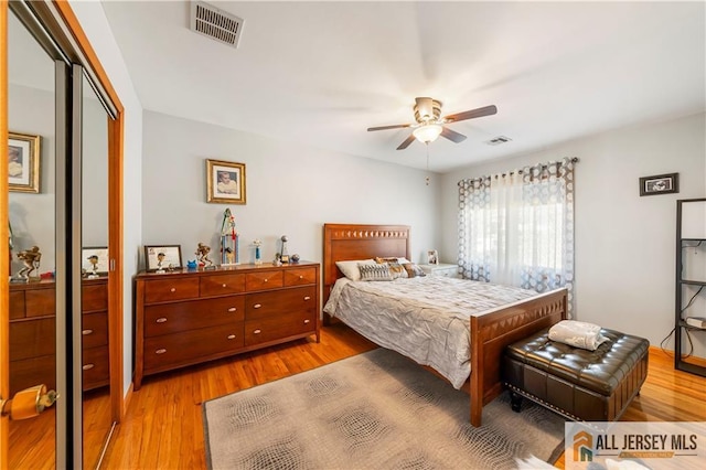 bedroom with visible vents, ceiling fan, a closet, and wood finished floors