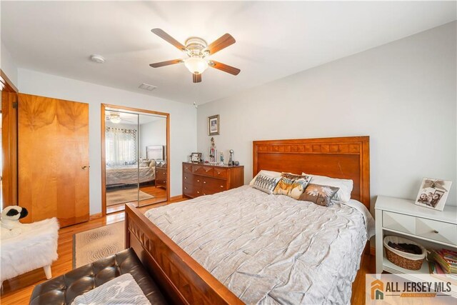 bedroom featuring visible vents, a closet, ceiling fan, and wood finished floors