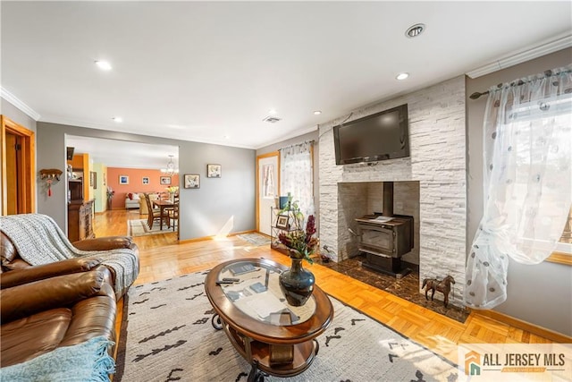 living area with a wood stove, ornamental molding, visible vents, recessed lighting, and baseboards