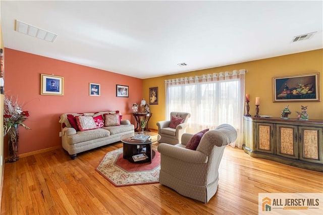 living room featuring visible vents and light wood-style floors