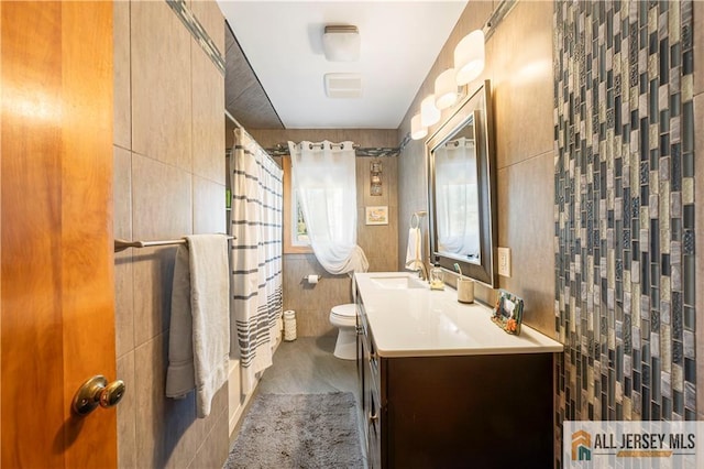 full bathroom with vanity, tile walls, a shower with curtain, and toilet