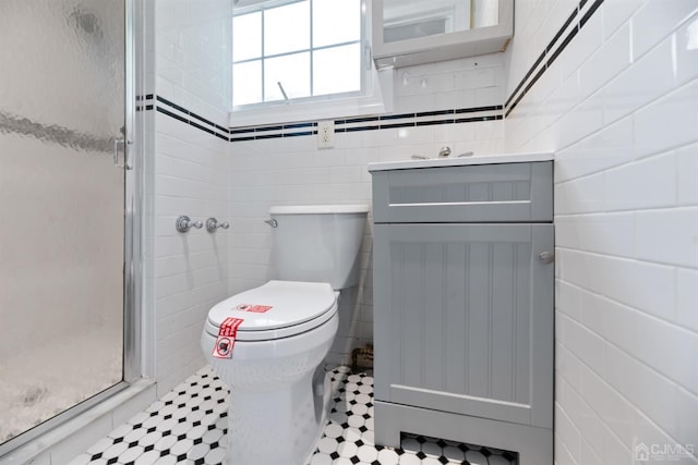 full bath featuring tile walls, a shower stall, toilet, and vanity