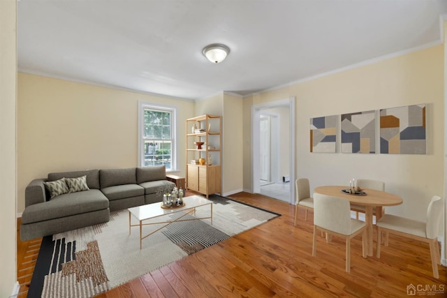 living area with wood finished floors, crown molding, and baseboards