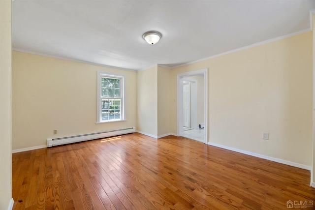 empty room featuring a baseboard heating unit, baseboards, ornamental molding, and wood-type flooring