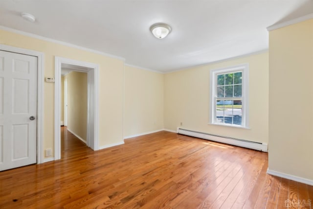 empty room with a baseboard radiator, wood finished floors, ornamental molding, and baseboards