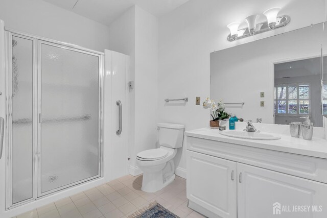 bathroom featuring an enclosed shower, vanity, tile patterned floors, and toilet