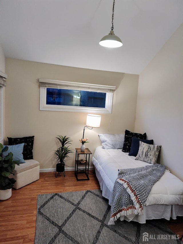 bedroom with vaulted ceiling and hardwood / wood-style floors