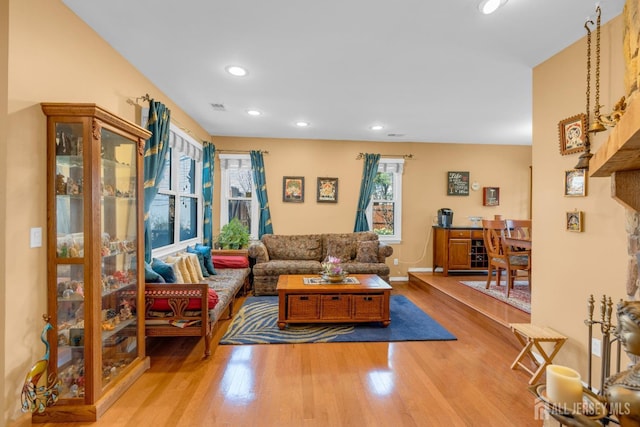 living area with recessed lighting, baseboards, visible vents, and wood finished floors
