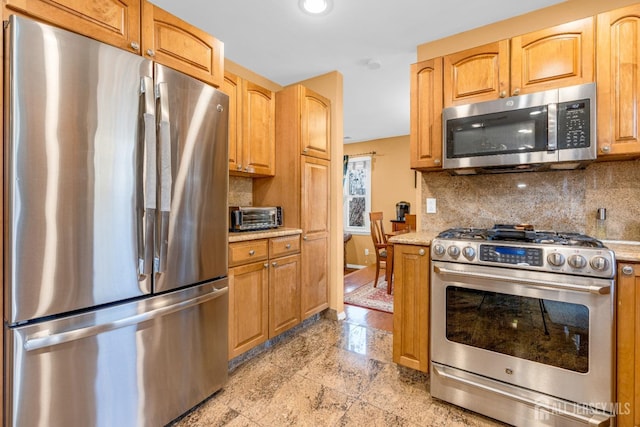 kitchen with light stone counters, stainless steel appliances, recessed lighting, a toaster, and backsplash