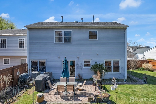 back of property featuring a lawn, a fenced backyard, central AC unit, and a patio