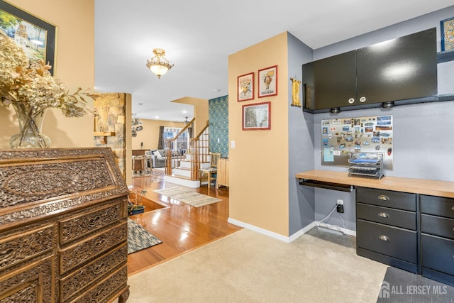 interior space featuring baseboards, carpet flooring, stairs, and built in desk