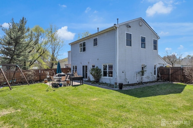 back of property featuring a fenced backyard, a patio, and a lawn